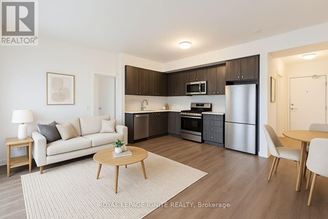 A modern kitchen with dark brown cabinets and stainless steel appliances.