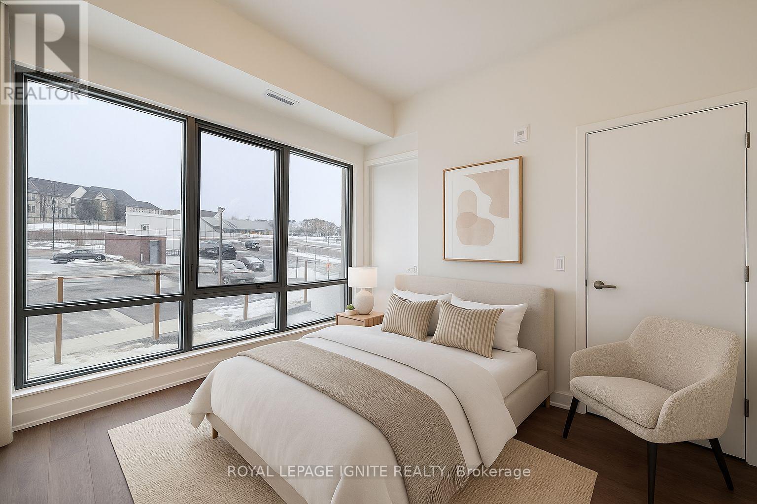 A bedroom with a large bed and a chair.