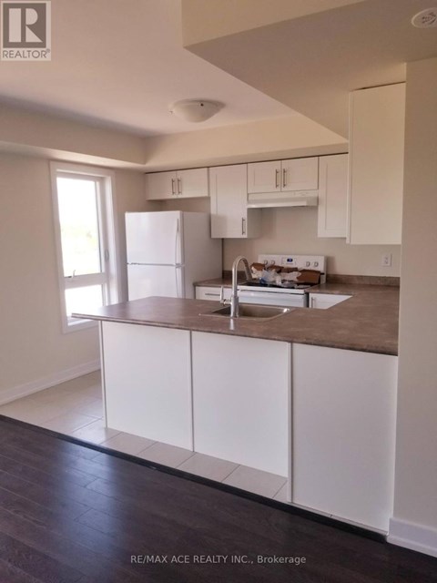 A kitchen with white cabinets and a brown countertop.
