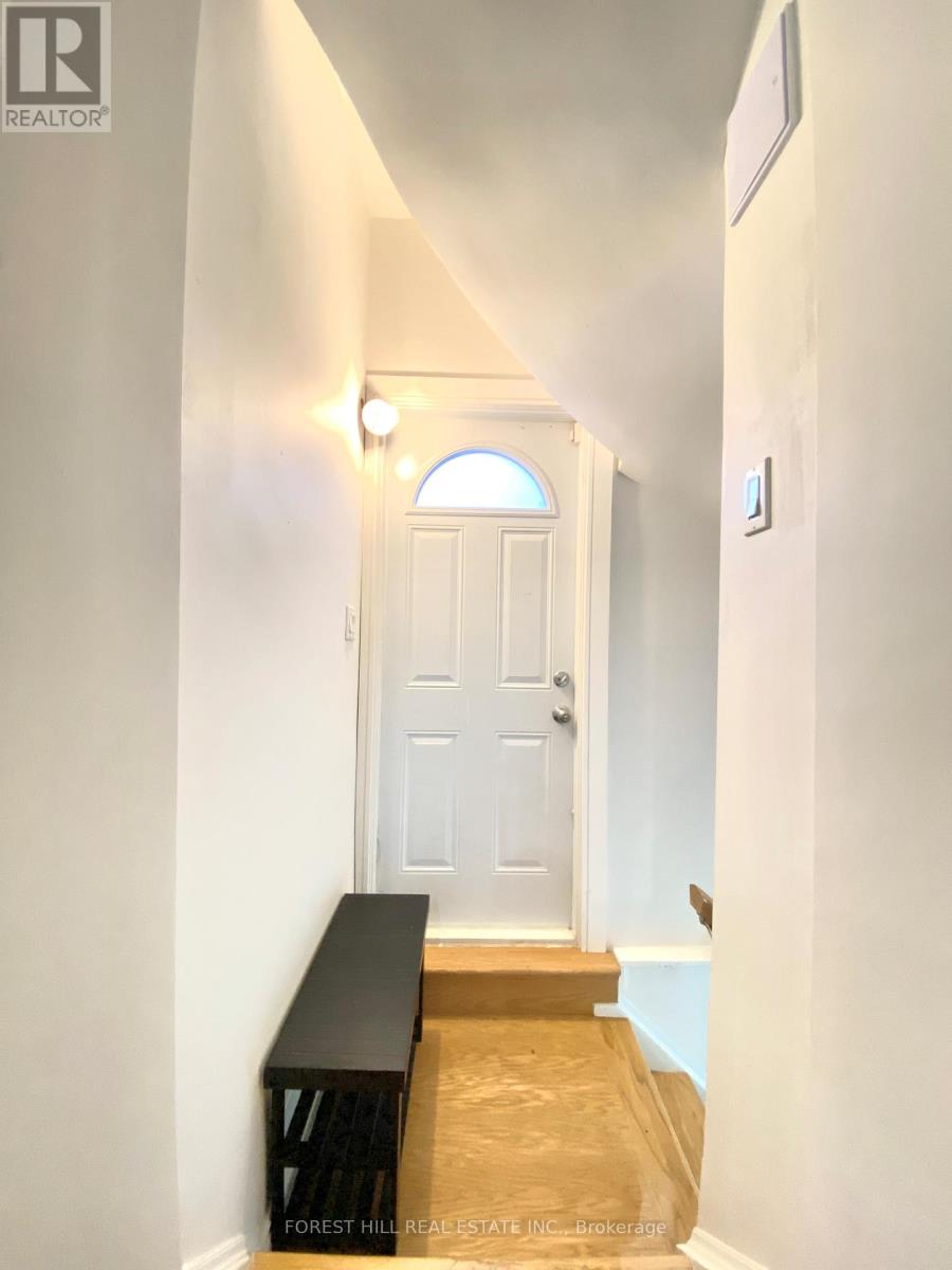 A hallway with a white door and a bench at the bottom.
