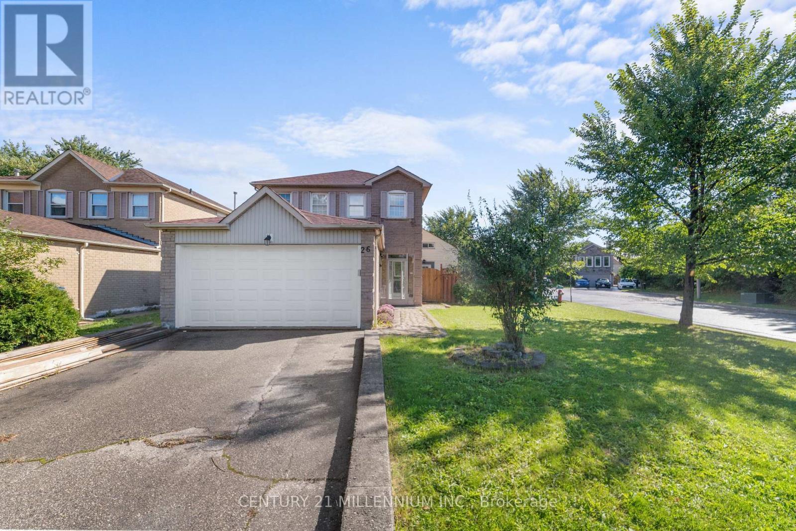 A realtor photo of a house with a garage and a tree in front.