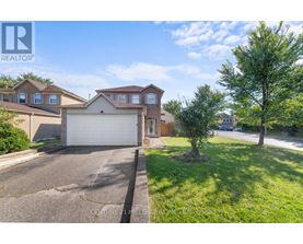 A realtor photo of a house with a garage and a tree in front.