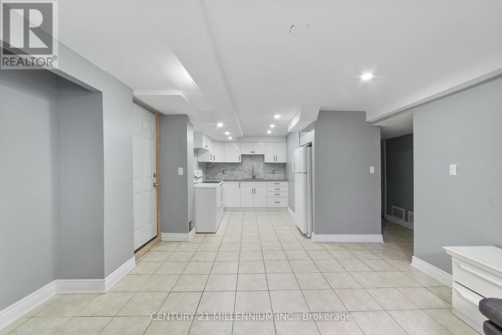 A spacious kitchen with white cabinets and appliances.