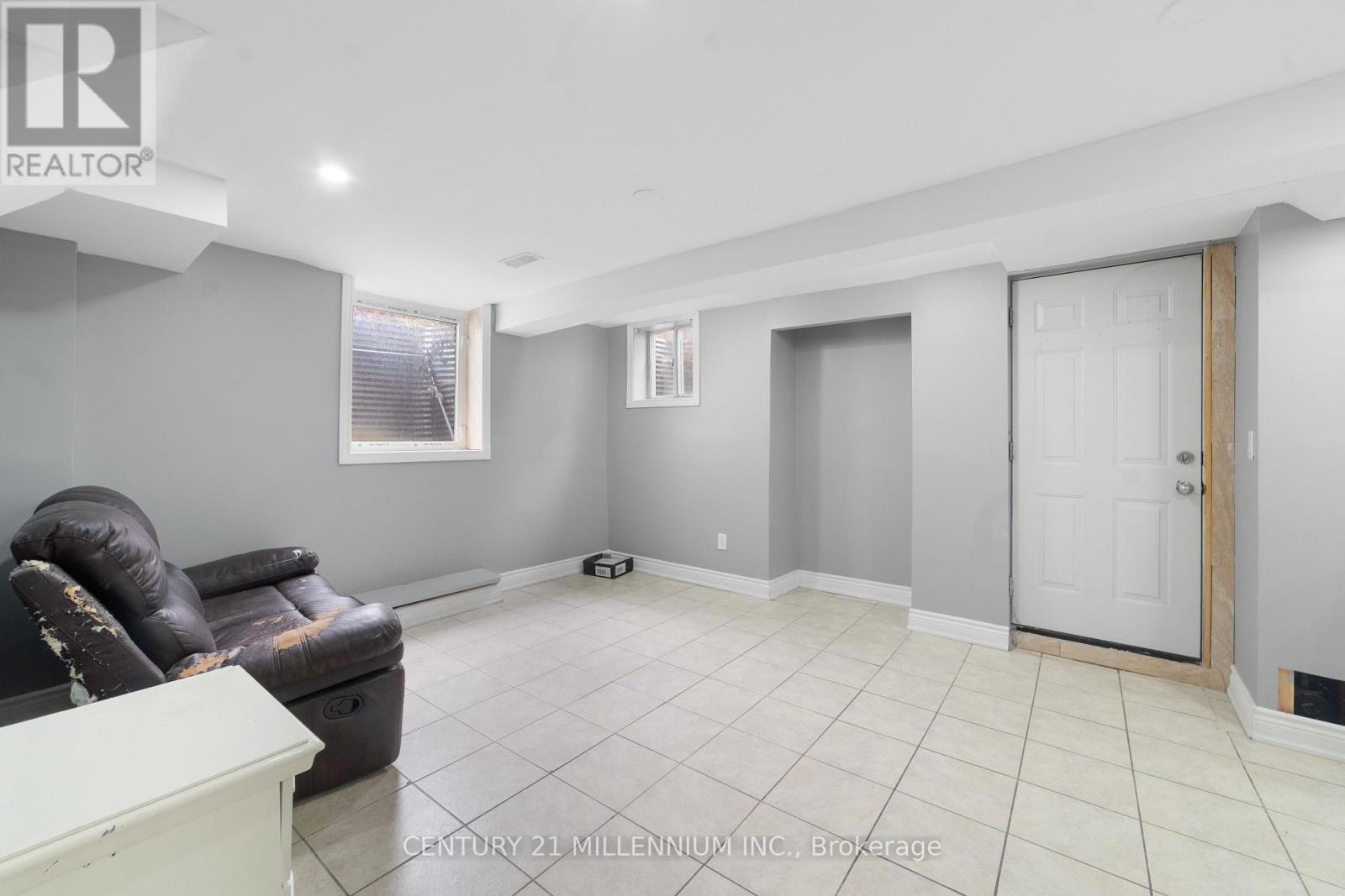 A room with a black leather chair and a white cabinet.