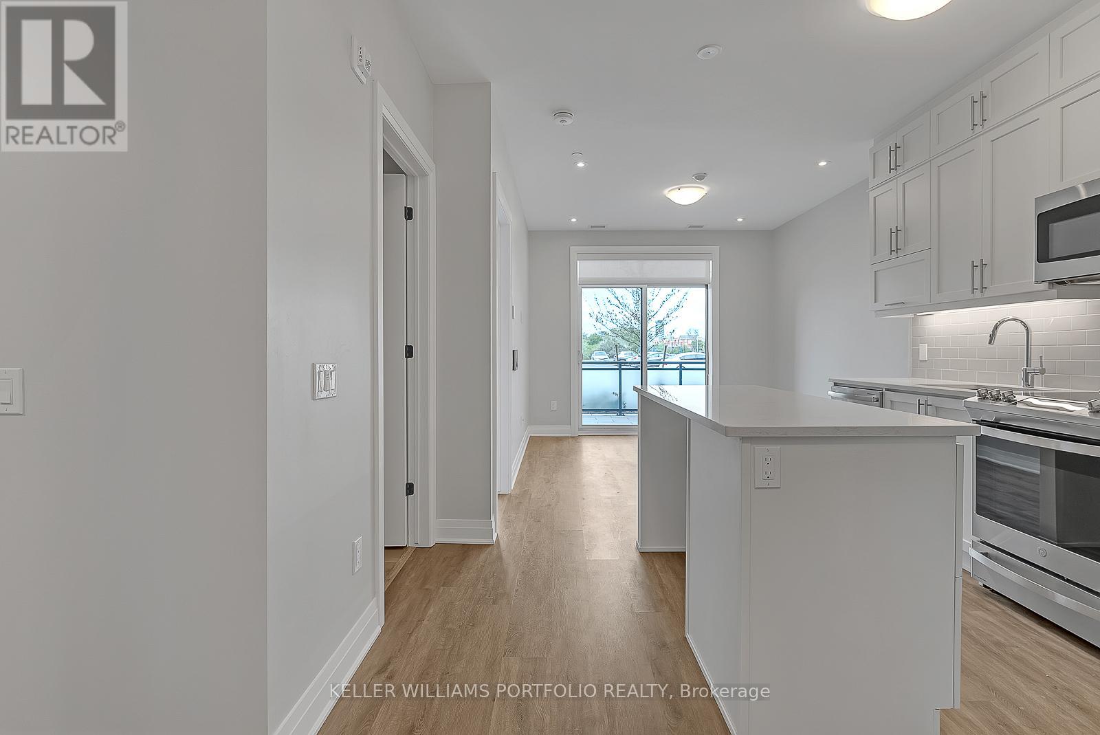 A kitchen with white cabinets and a window.