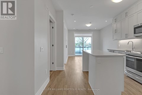 A kitchen with white cabinets and a window.