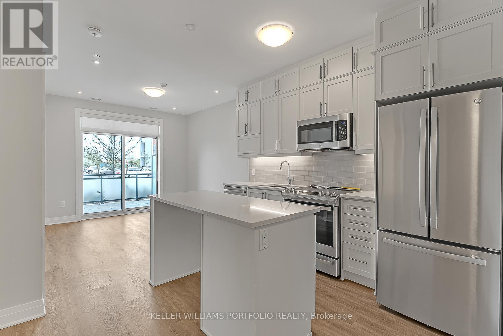 A modern kitchen with stainless steel appliances and white cabinets.