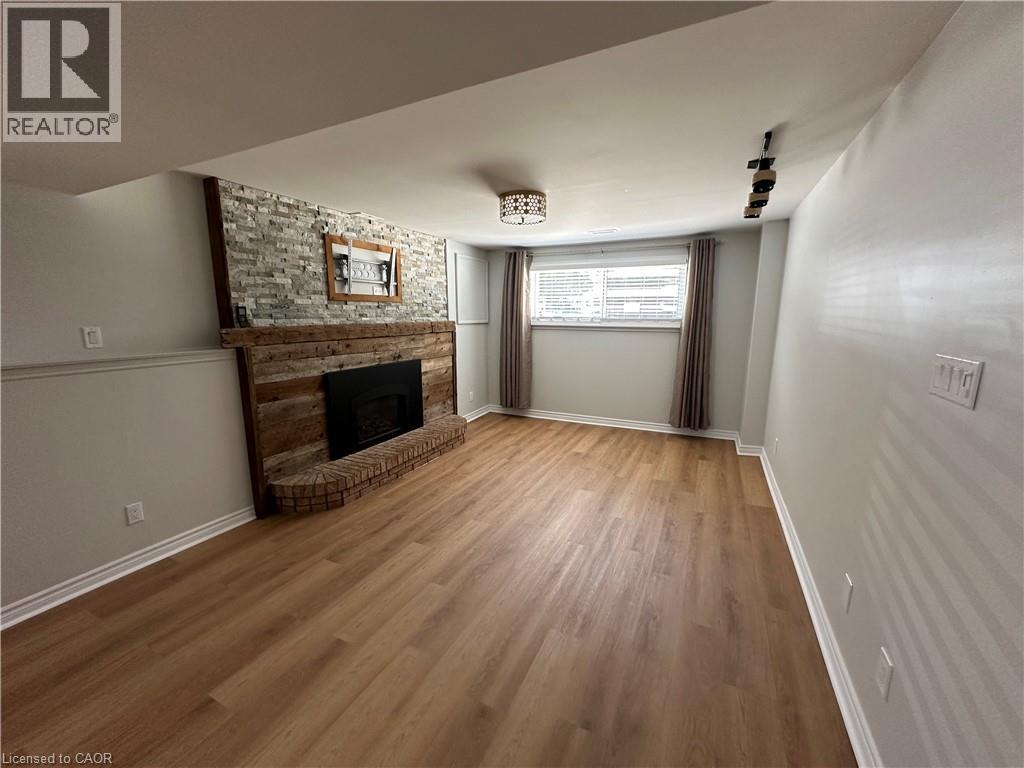 A living room with a fireplace and wooden floors.
