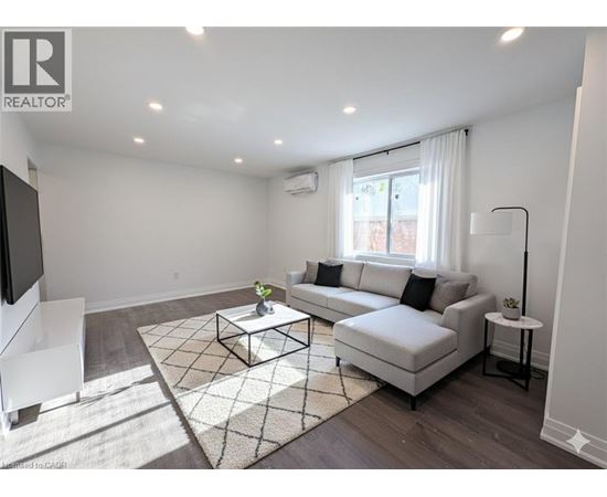 A living room with a white couch, a coffee table, and a rug.