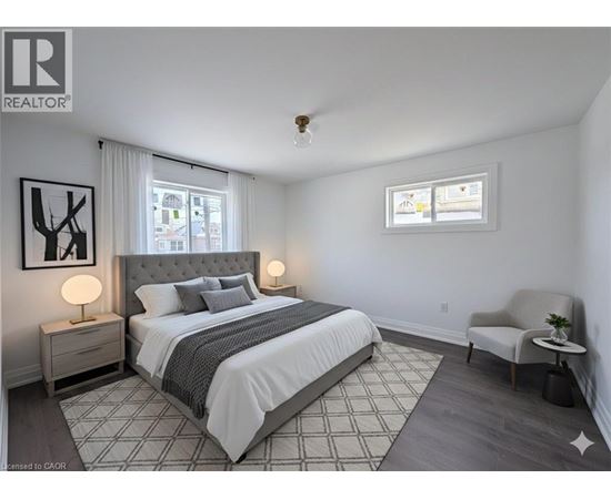 A bedroom with a large bed, a chair, and a window.