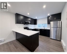 A modern kitchen with black cabinets and a white countertop.