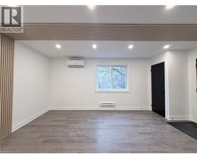 A spacious room with a window and a door on the right side.