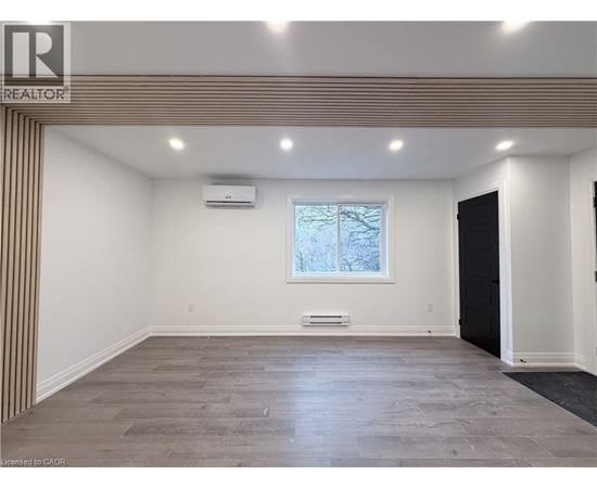 A spacious room with a window and a door on the right side.