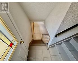 A hallway with a staircase leading to the second floor.