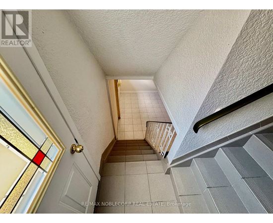 A hallway with a staircase leading to the second floor.