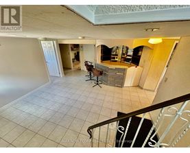 A spacious living room with a staircase leading to the upper floor.