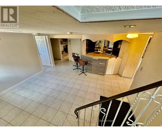 A spacious living room with a staircase leading to the upper floor.
