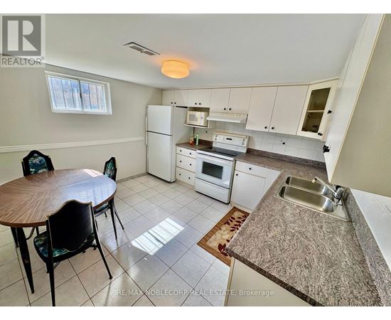A kitchen with a table and chairs in it.