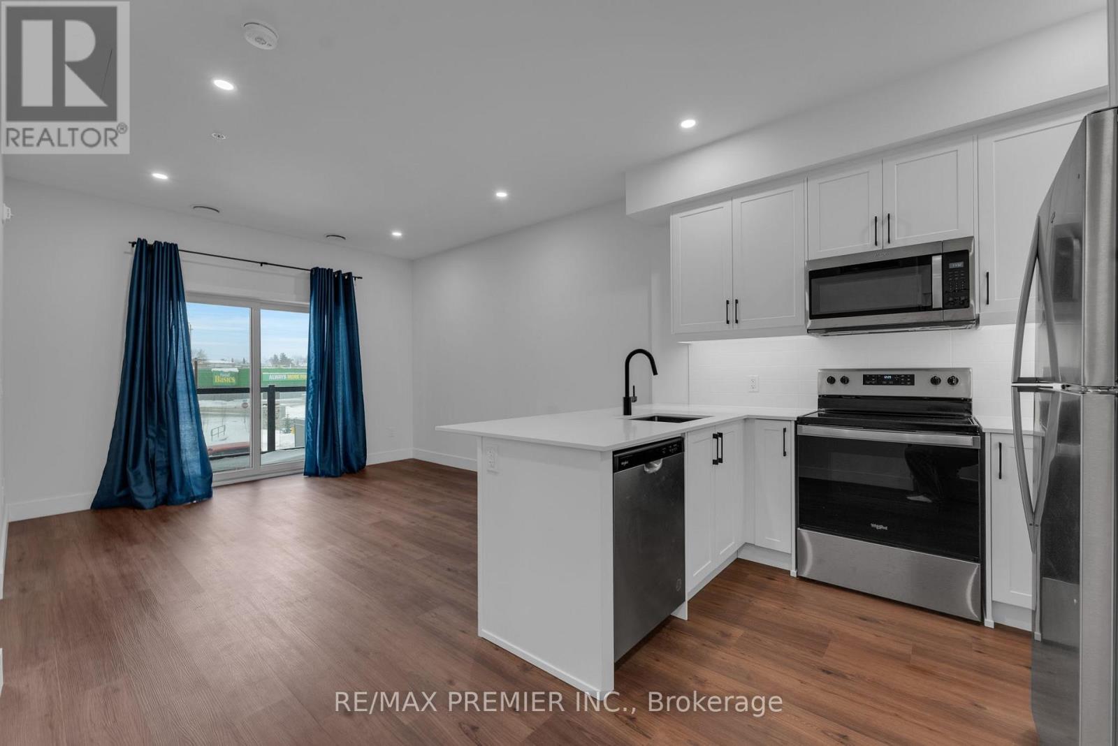 A modern kitchen with white cabinets and stainless steel appliances.