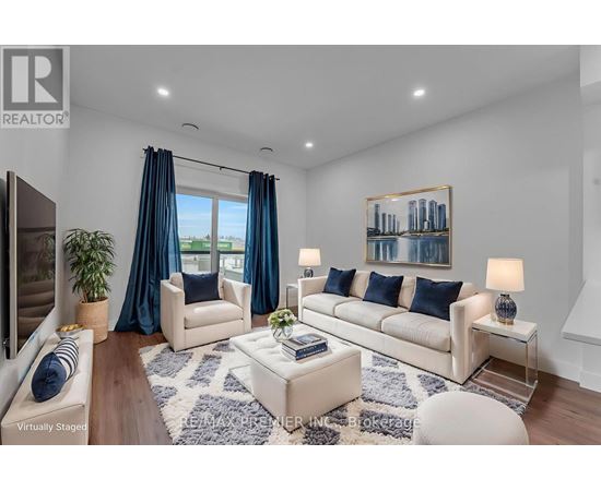 A living room with a white sofa, a coffee table, and a painting on the wall.
