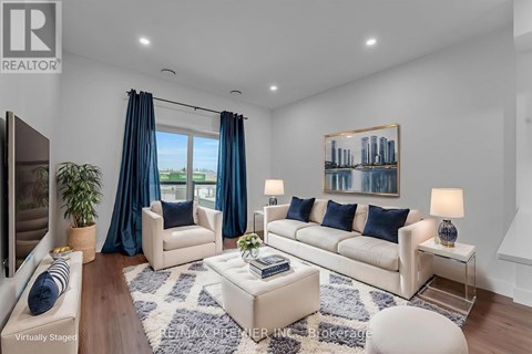 A living room with a white sofa, a coffee table, and a painting on the wall.