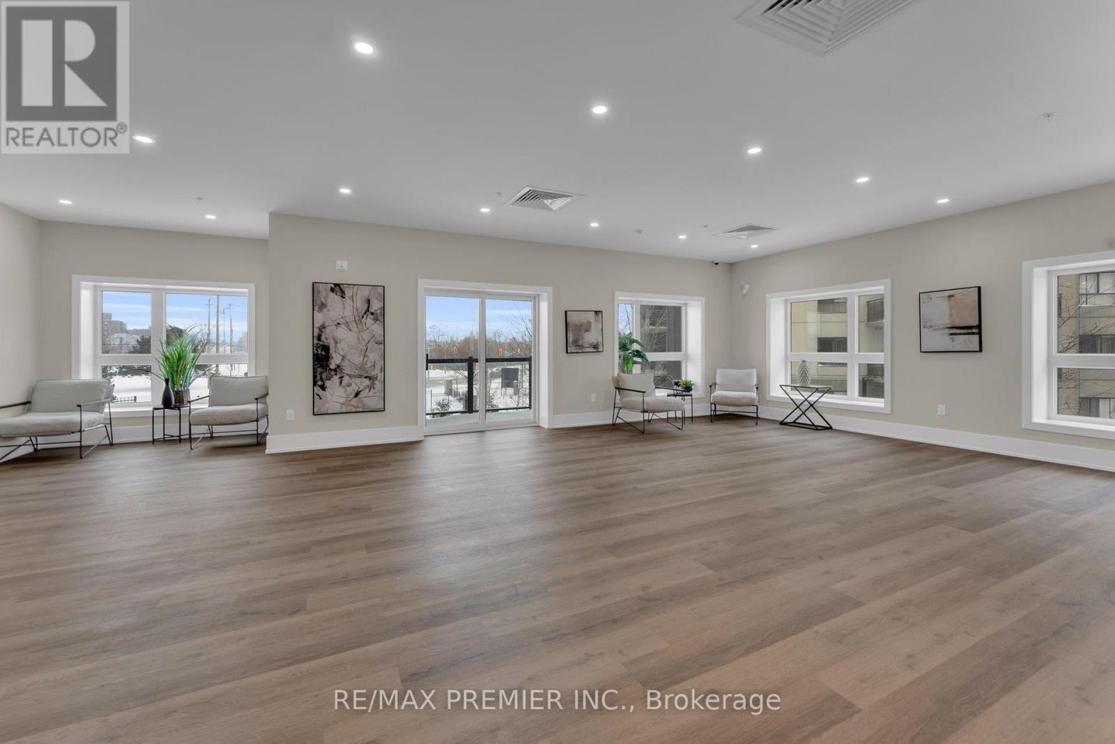 A spacious room with wooden floors and white walls, furnished with a sofa set and a coffee table.