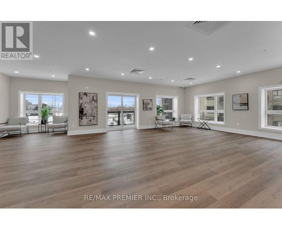 A spacious room with wooden floors and white walls, furnished with a sofa set and a coffee table.