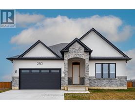 A modern house with a stone facade and a black garage door.