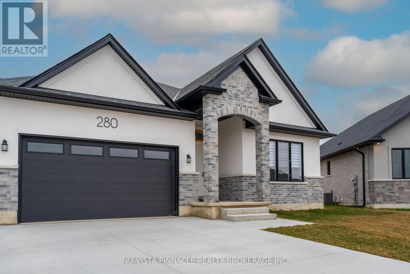 A modern house with a stone pillar entrance and a garage door.