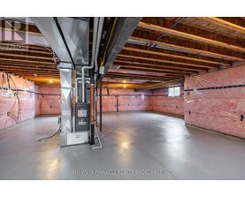 A spacious attic room with insulation and a furnace.