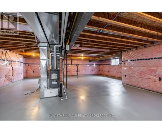A spacious attic room with insulation and a furnace.