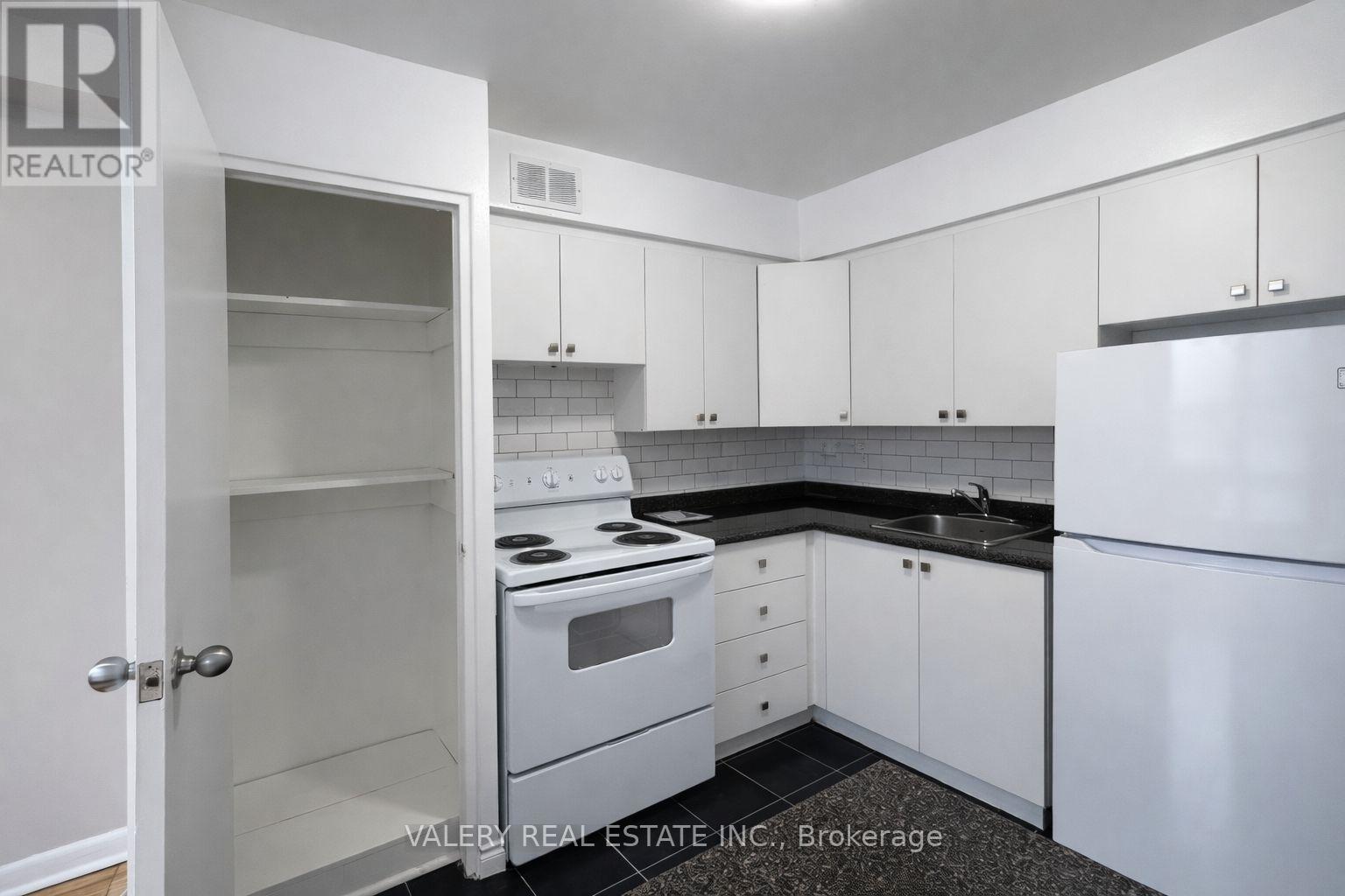 A kitchen with white appliances and cabinets.
