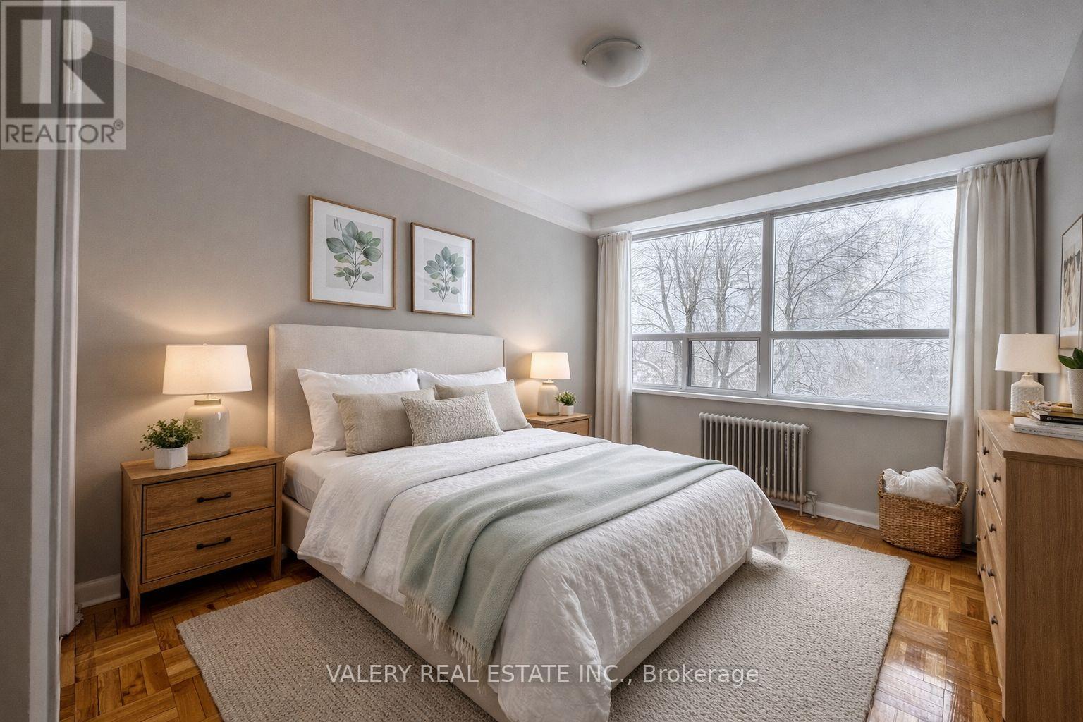 A bedroom with a large bed, two nightstands, and a window.