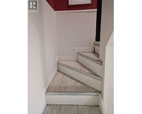 A staircase with a red wall in the background.