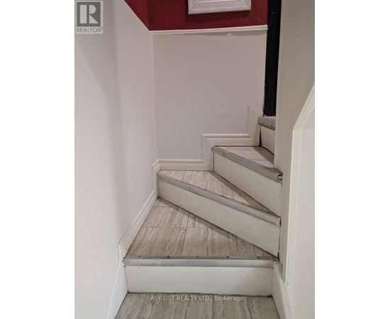 A staircase with a red wall in the background.
