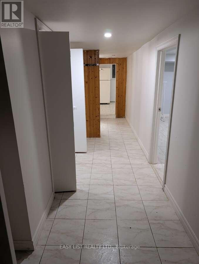 A long hallway with white tile floors and white walls.