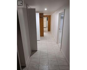 A long hallway with white tile floors and white walls.