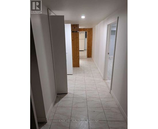 A long hallway with white tile floors and white walls.
