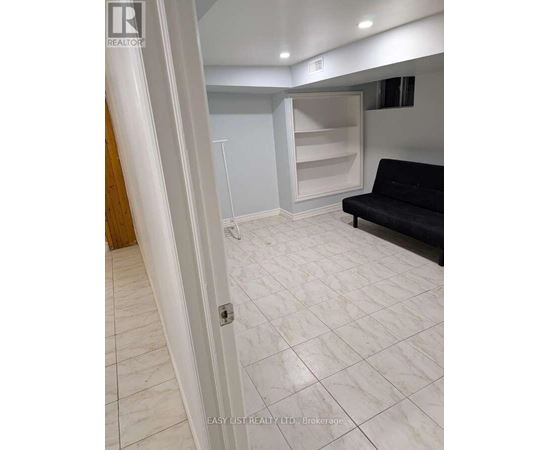 A living room with a black couch and a white door.