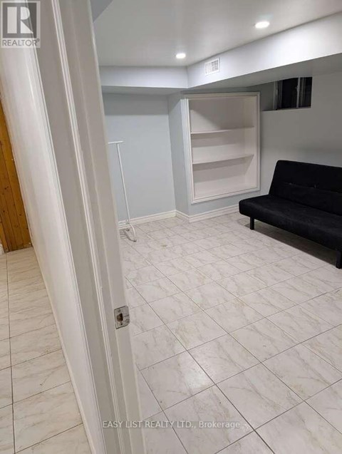 A living room with a black couch and a white door.