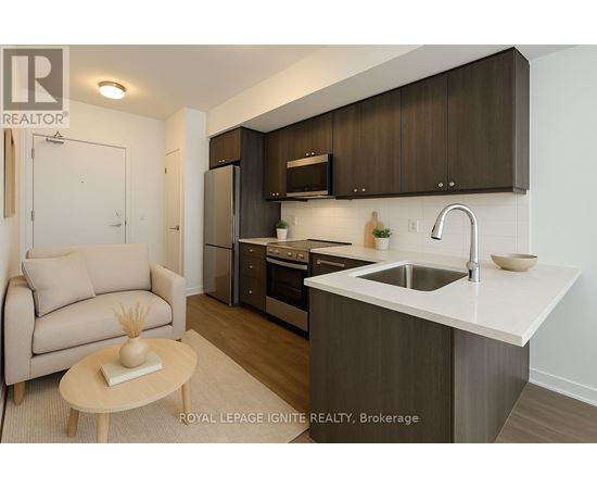 A modern kitchen with a sink, refrigerator, and cabinets.