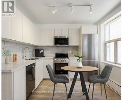 A modern kitchen with a round table and chairs.