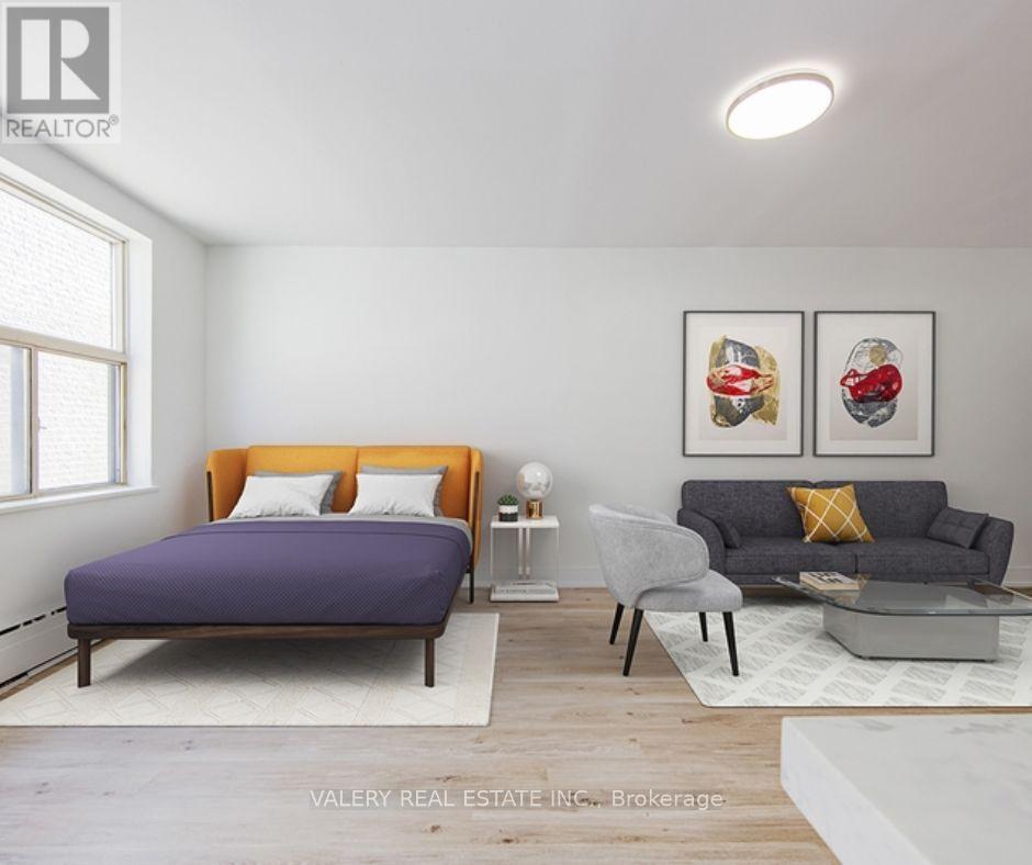A bedroom with a purple bed and a grey couch.