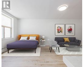 A bedroom with a purple bed and a grey couch.