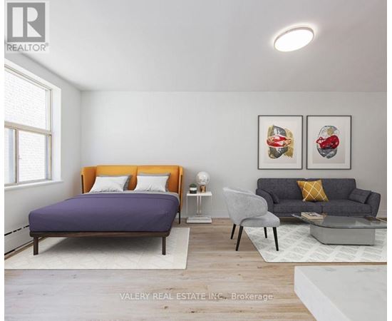 A bedroom with a purple bed and a grey couch.