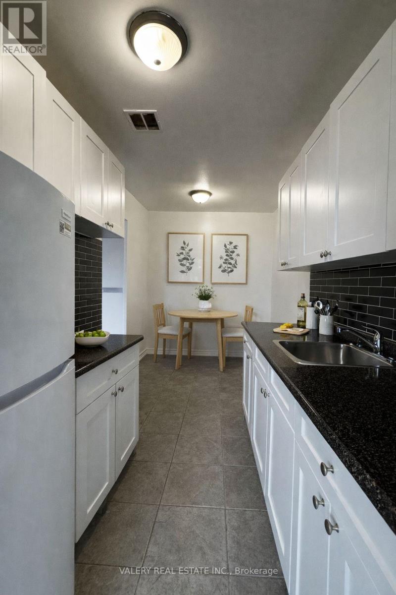 A kitchen with white cabinets and a black countertop.