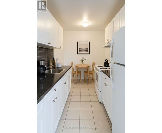 A kitchen with white cabinets and appliances.