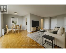 A living room with a couch, chairs, and a television.