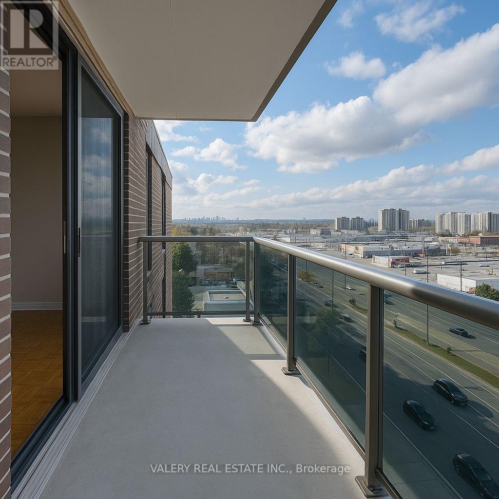 A balcony with a glass railing overlooking a cityscape.