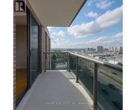 A balcony with a glass railing overlooking a cityscape.